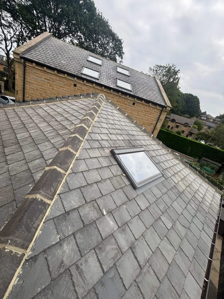 Completed slate roof with a newly fitted roof window