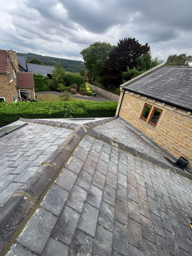 Slate roof viewed from above overlooking a stone gabled house and countryside